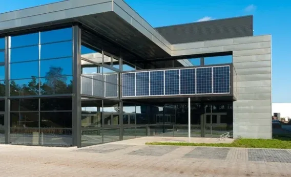 Immeuble de bureaux contemporain avec façade vitrée et panneaux photovoltaïques.