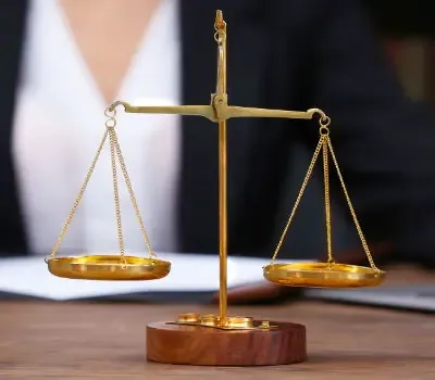 Balance de justice dorée posée devant un dossier.