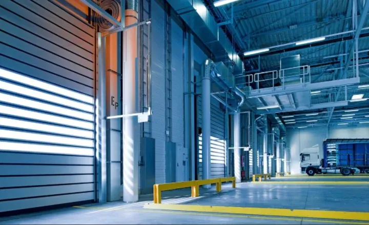 Intérieur d’un bâtiment industriel avec quais de chargement et structure métallique.
