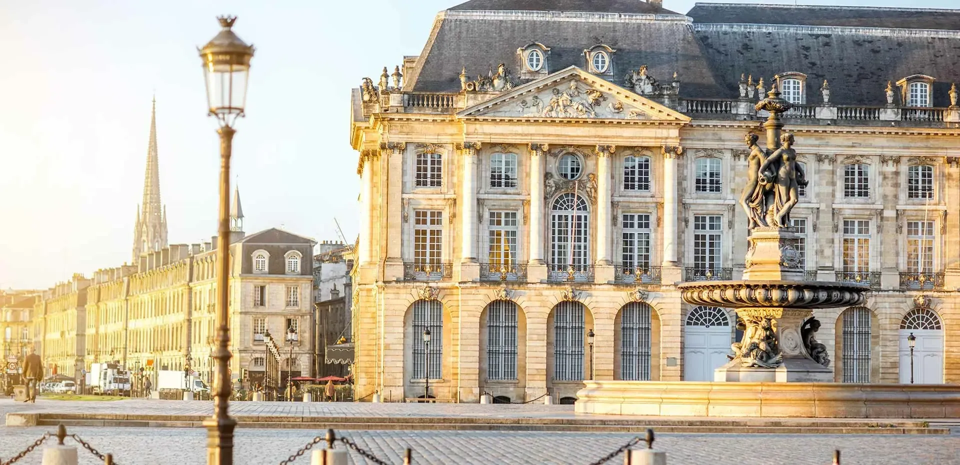 Architecture classique de la place de la Bourse à Bordeaux, éclairée par une lumière dorée.
