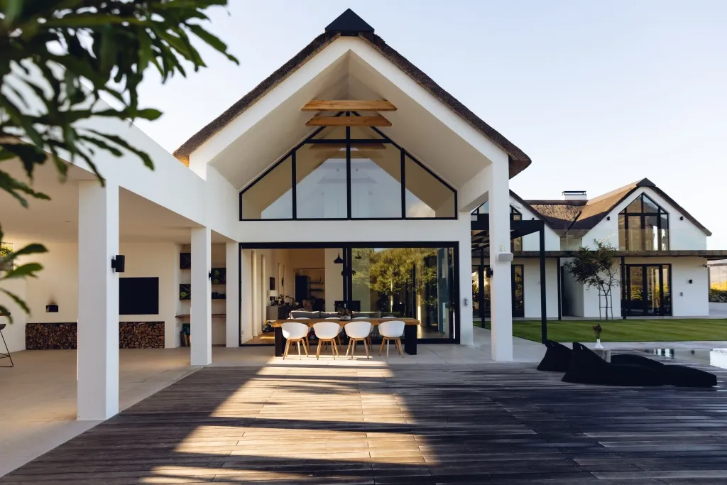 Maison contemporaine de prestige avec terrasse en bois et grandes baies vitrées.